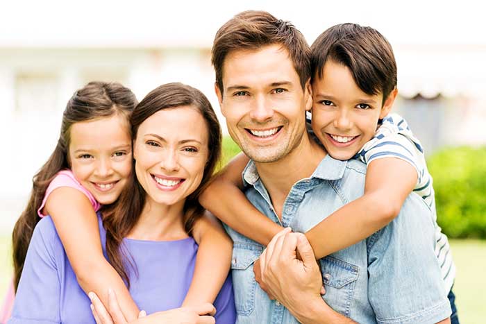 happy family in front a house on a sunny day